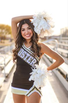 a cheerleader posing for the camera with her pom poms