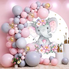 an elephant surrounded by balloons and flowers on a pink wall with gold confetti