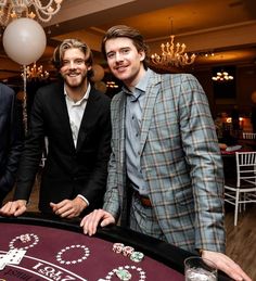 three men standing next to each other at a casino table