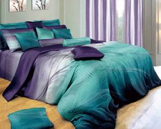 a bed with purple and teal comforters on top of it in a room