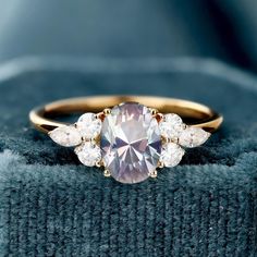 an engagement ring with three stones on it and a blue blanket in the back ground