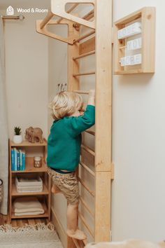 a young boy climbing up the side of a wooden bunk bed