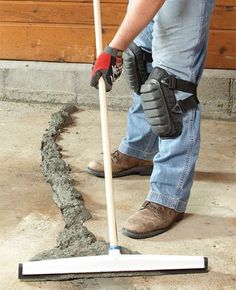 a man using a mop to clean concrete