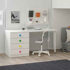 a white desk with two drawers and a chair next to it in a small room