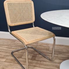 a chair sitting on top of a hard wood floor next to a white marble table