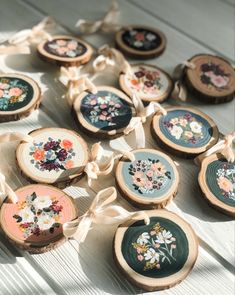 wooden slices with flowers painted on them sitting on a table next to ribbons and bows