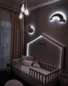 a baby's room with a crib and lights on the wall above it