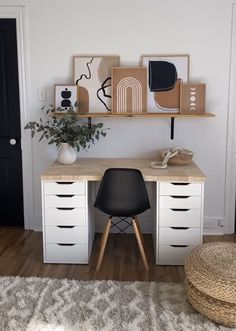 a white desk topped with lots of drawers next to a wall mounted art on top of a wooden shelf