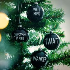 three ornaments hanging from a christmas tree with words on them