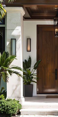 a wooden door with two planters in front of it on the side of a house