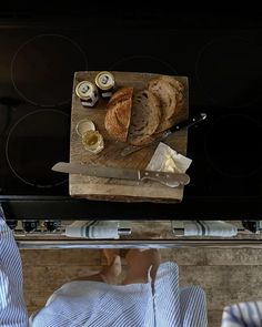 a person sitting in front of an oven with food on it