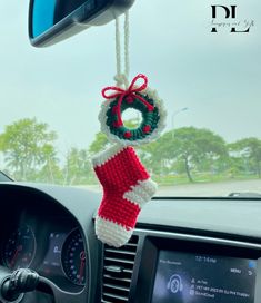 a knitted christmas stocking hanging from the dashboard of a car with a steering wheel