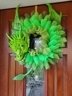 a green wreath hanging on the front door