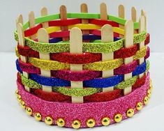 the colorful bracelets are stacked on top of each other with wooden sticks sticking out of them