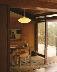 a dining room with wood paneling and sliding glass doors