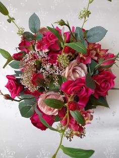 a bouquet of red and pink flowers on a white background