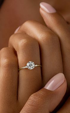 a woman's hand with a diamond ring on it