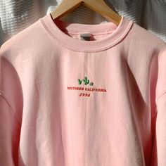 "*SIZES ARE UNISEX* -For women, I'd suggest your usual size for a regular fit (size up for a more relaxed fit). Men should size up for a more relaxed fit. *these sweatshirts are extra comfy when oversized 🌵NEW! \"Southern California 1996\" and a cute cacti design embroidered on a comfy vintage-style pink crewneck. Perfect for any occasion or gift for him or her. A sturdy and warm sweatshirt bound to keep you warm in the colder months. A pre-shrunk, classic fit sweater that's made with air-jet s Spring Crew Sweatshirt With Embroidered Logo, Spring Sweatshirt With Embroidered Logo And Crew Neck, Spring Crew Neck Sweatshirt With Embroidered Logo, Casual Crew Sweatshirt With Embroidered Graphics, Casual Pink Sweatshirt With Embroidered Logo, Spring Relaxed Fit Sweater With Embroidered Graphics, Relaxed Fit Embroidered Sweater For Spring, Spring Crew Sweatshirt With Embroidered Text, Pink Sweatshirt With Embroidered Logo For Spring