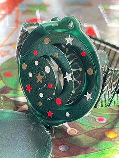 a green watch sitting on top of a table covered in confetti and stars