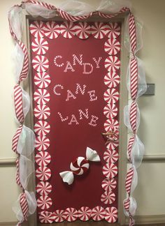 a door decorated with red and white candy canes, bows and the words candy land on it