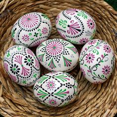 painted eggs in a wicker basket on the ground