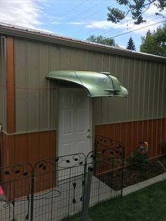 a small metal shed with a green awning over the door