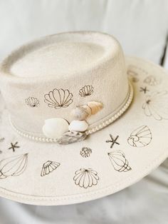 This fedora reflects fond moments when my daughter and I collect seashells on the beach. It's a cherished time to connect together and a sense of peace with each other walking along with the suns pink/orange hues and the waves crashing beside us.    I custom designed and hand crafted this fedora. this is a timeless art piece.   Each hat is 100% unique. I spend time hand drawing and illustrating each design and use my workshop to engrave and add the finishing touches using a multitude of mediums Custom Wide Brim Fedora For Beach, Custom Wide Brim Fedora For The Beach, Custom Beach Fedora With Curved Brim, Custom Fedora For Beach, Custom White Hat Bands For Beach, Custom White Hats For The Beach, Collect Seashells, Seashells On The Beach, Spring Tote Bag