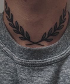 a man's neck with a laurel tattoo on it