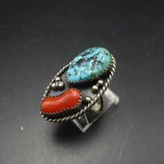 "VINTAGE NAVAJO RING DESCRIPTION: This ring features an exquisite cabochon old Kingman turquoise, anchored with a stunning specimen of old red Mediterranean branch coral. Applied raindrops punctuate the dark patina background. This impressive ring will be a treasured addition to your collection of fine vintage Native American jewelry. MEASUREMENTS: Ring face measures 1 1/4\" x 3/4\" Turquoise cabochon measures 17mm x 11mm RING SIZE: 7 1/4 WEIGHT: 8.0 grams SIGNED: WL, for Willie Long (Navajo) ST Vintage Multi-stone Oval Cabochon Rings, Antique Oval Turquoise Ring, Antique Turquoise Gemstone Ring, Antique Turquoise Anniversary Ring, Vintage Turquoise Ring With Oval Cabochon, Vintage Turquoise Oval Cabochon Ring For Anniversary, Antique Untreated Turquoise Jewelry, Southwestern Multi-stone Oval Turquoise Ring, Southwestern Oval Turquoise Multi-stone Ring