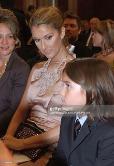 two women and a child sitting next to each other in front of a group of people