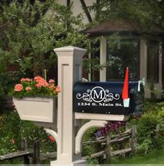 a mailbox with a monogrammed letter on it in front of a house