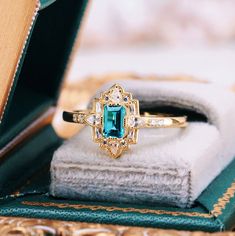 Step into the elegance of a bygone era with our Natural London Blue Topaz Ring, beautifully set in 14K yellow gold vermeil. This exquisite engagement ring draws inspiration from the opulent Art Deco period, blending vintage charm with timeless sophistication.►The centerpiece is a stunning London blue topaz, renowned for its deep, captivating hue that evokes the mysterious beauty of twilight skies. The intricate detailing of the band, adorned with delicate filigree patterns and sparkling accents, Elegant Yellow Gold Emerald-cut Topaz Ring, Elegant Emerald Cut Yellow Gold Topaz Ring, Elegant Yellow Gold Emerald Cut Topaz Ring, Classic Topaz Birthstone Ring For Wedding, Heirloom Topaz Ring For Promise, Victorian Gold Emerald Ring For Wedding, Victorian Emerald Ring For Wedding, Elegant Topaz Promise Jewelry, Elegant Blue Birthstone Ring With Rose Cut Diamonds