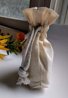 a small bag sitting on top of a table next to flowers