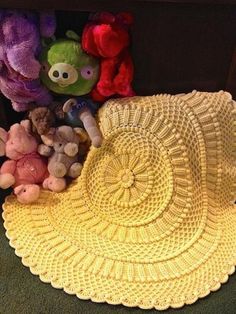 several stuffed animals sitting on the floor next to a crocheted doily