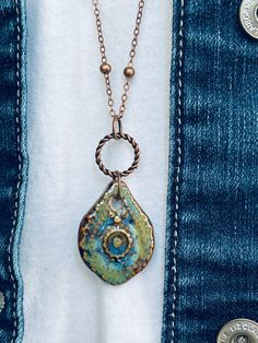 "This is a gorgeous boho long pendant necklace with a handmade ceramic pendant that carries lovely greens and blues mixed with rustic light and copper browns.  The pendant hangs from a 30-inch antique copper satellite chain with a 2-inch extension chain (the pendant and connectors add an additional 2 inches).  The pictures simply don't do this necklace justice!!  Perfect to wear with your casual everyday outfits or style up a dressy outfit! **Each piece of Daisy Light Jewelry is delivered packaged in a brown kraft box with an organza bow and charm.  If you have two or more boxes, I will note what is in each box for easy gift giving. **My \"professional photographer\" is yours truly, so any and all color differences are due to my camera, computer and the sunlight.  I do my best to represent Lovely Greens, Pottery Jewelry, Rustic Light, Organza Bow, Rustic Necklace, Dressy Outfit, Light Jewelry, Poly Clay, Ceramic Necklace