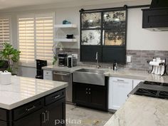 a kitchen with black cabinets and white marble counter tops is pictured in this image from the front view