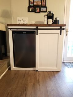 a kitchen area with a refrigerator and coffee maker