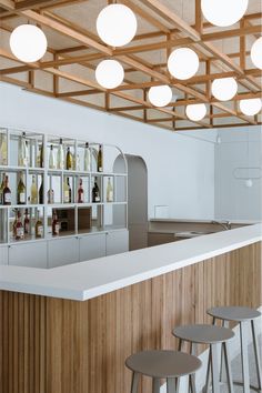 an empty bar with stools and bottles on the shelves