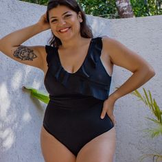 Get ready to shine in our stunning black one-piece swimsuit. This piece features a chic straight-line V-neck with a playful ruffled overlay, adding a fun twist to your beach look. Enjoy adjustable straps, removable padding, and modest coverage for the perfect fit and ultimate comfort. Made from smooth, stretchy fabric with double lining, this swimsuit stays non-see-through even when wet, so you can feel confident and stylish all day. Embrace your inner beach goddess and make waves in this must-h Black One-piece Swimsuit With Lined Body For Beach, Black V-neck Elastane Swimwear, Black V-neck One-piece Beachwear, Stretch V-neck One Piece Beachwear, Black Nylon V-neck Swimwear, Black One Piece Swimsuit, Black One Piece, Beach Look, Black Swimsuit