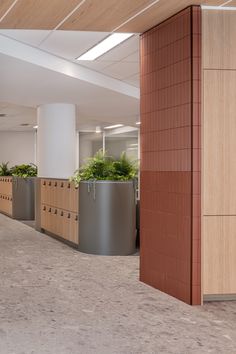 an empty office with planters on either side of the wall and large metal planters