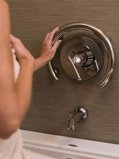 a woman is washing her hands under the faucet