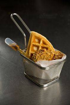 a waffle sitting on top of a metal container filled with syrup