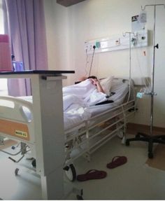 a person laying in a hospital bed with an iv drip attached to the wall next to them