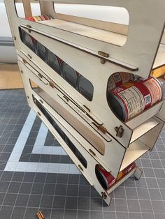 an old stove with two cans of wine in it's drawer on the floor