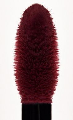 a close up view of the top of a makeup brush with red fur on it