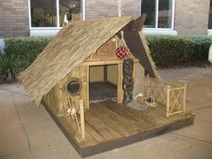 a dog house made out of wood with a thatched roof