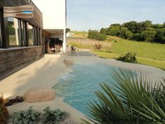 an outdoor swimming pool surrounded by plants and rocks