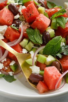 a salad with watermelon, cucumber, olives and feta cheese