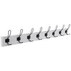 a white and black coat rack with five hooks on each side, hanging from the wall