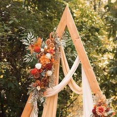 an orange and white wedding arch decorated with flowers